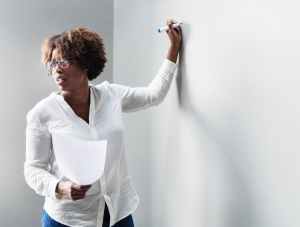woman writing in white board
